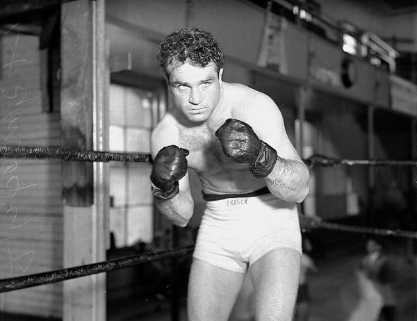 A man in boxing gloves is standing in the ring.