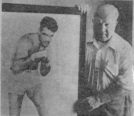 A man and an older gentleman holding boxing gloves.