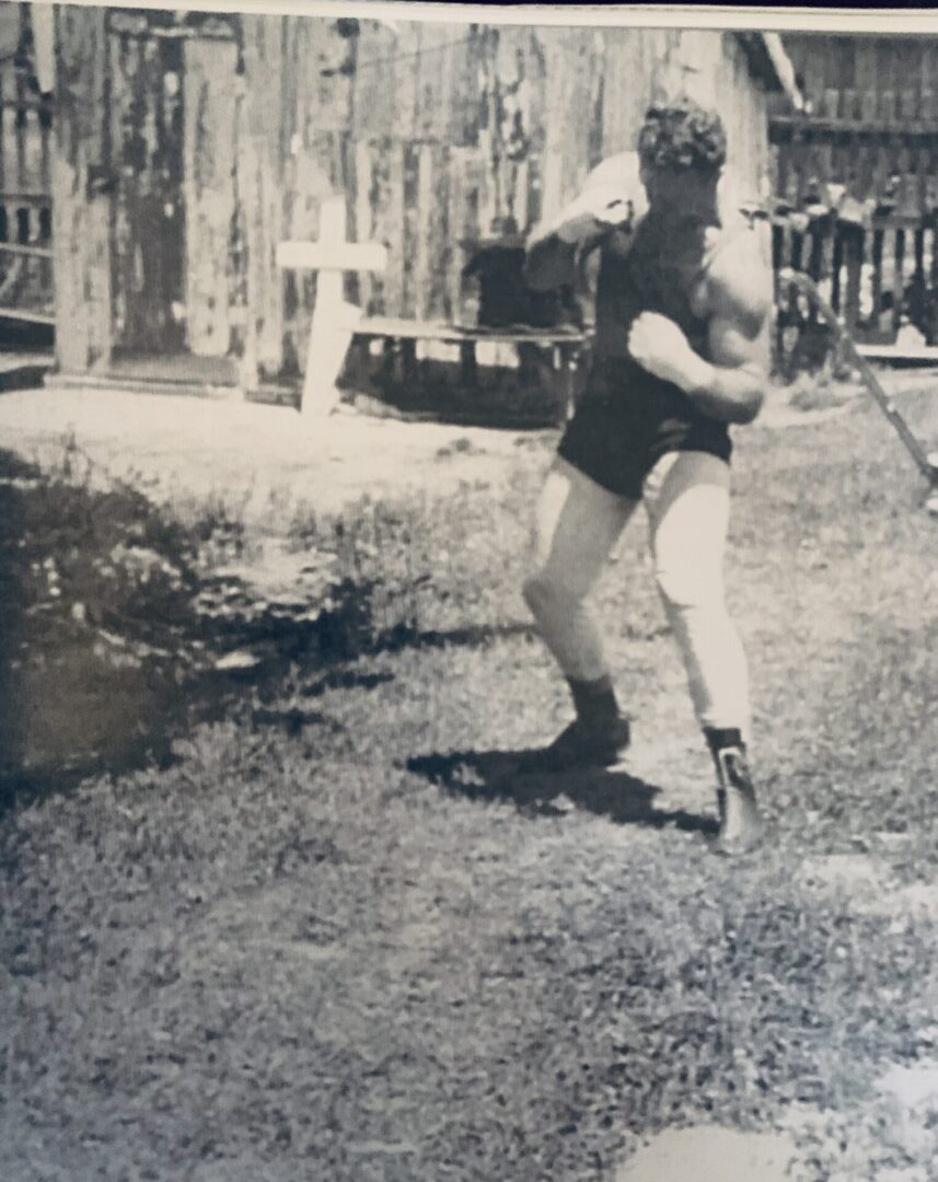 A man swinging a baseball bat in the grass.
