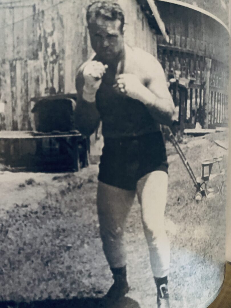 A man in black trunks is standing outside