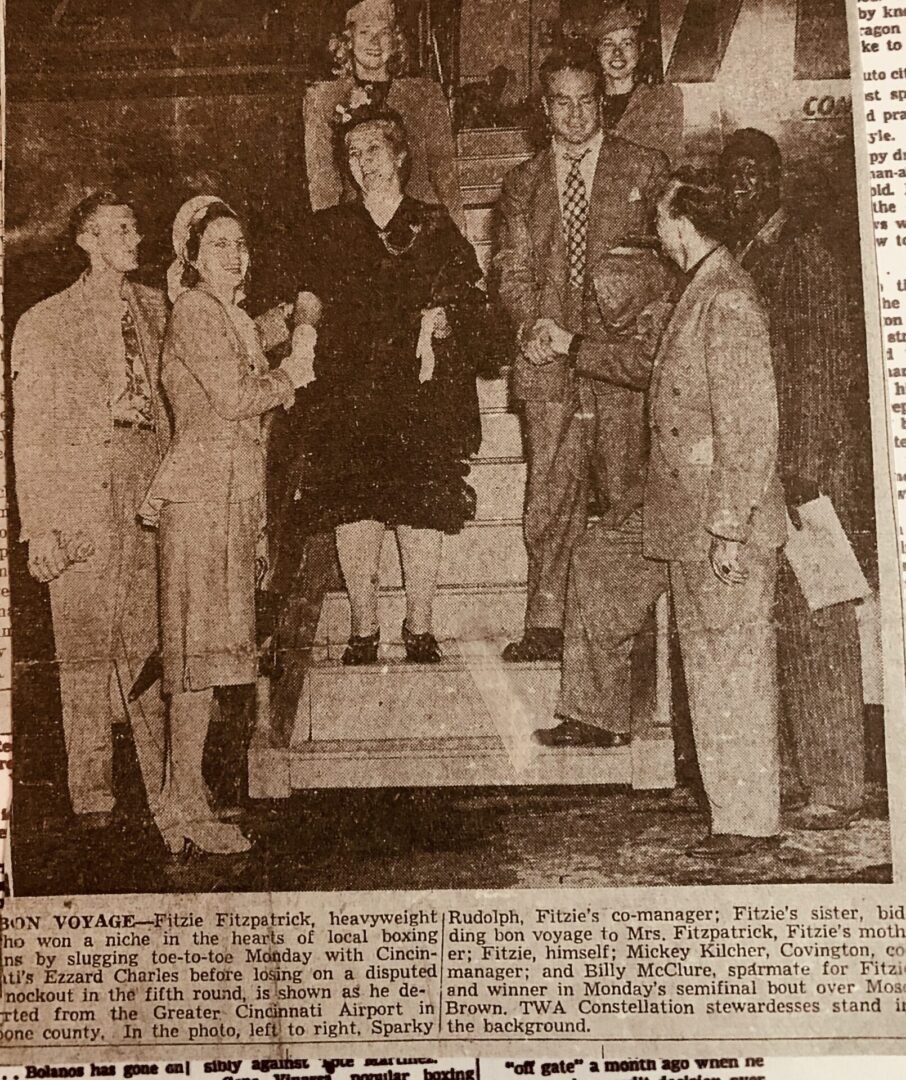 A newspaper article with an old photo of people standing on steps.