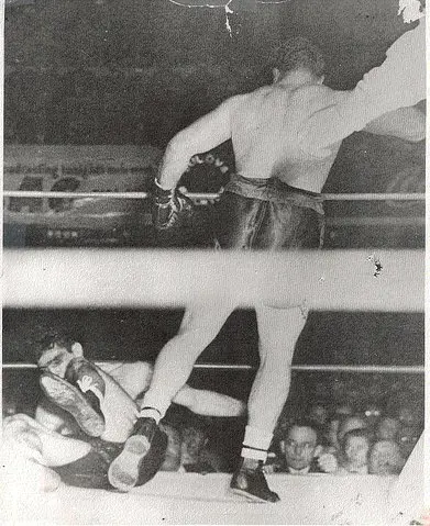 A man in the ring with his hands raised.